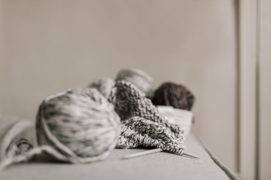A cozy scene featuring knitting needles, yarn, and a handmade project in a minimalist setting.